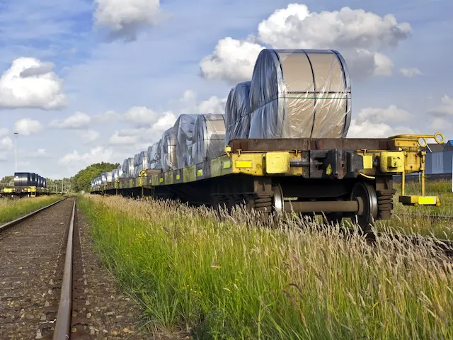 Een goederentrein met rollen staal staat stil op een spoor. Bouwen van een goederenspoor bedreigt de natuur bij Uitgeest, Heemskerk en Castricum.