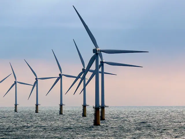 Windmolens op zee. Deze stroom moet ook op land vervoert worden. De trajecten kunnen mooie natuur bedreigen.